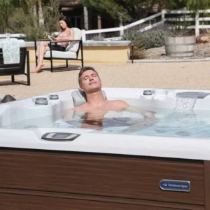 Husband Relaxing In A Sundance Hot Tub And Wife Reading A Book - Improve Sleep Patterns