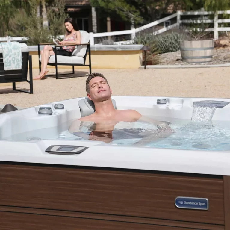 husband relaxing in a sundance hot tub and wife reading a book - improve sleep patterns