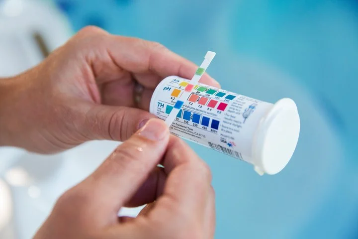 Man Checking Water Chemistry With Ph Test Strips - Hot Tub Service And Repair 