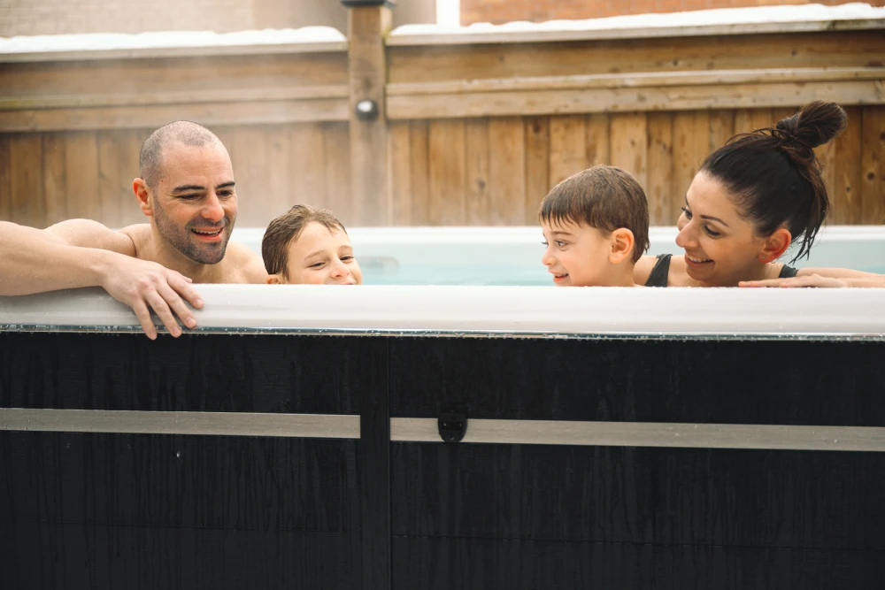 Young Family Enjoying An Outdoor Swim Spa Swim Spa